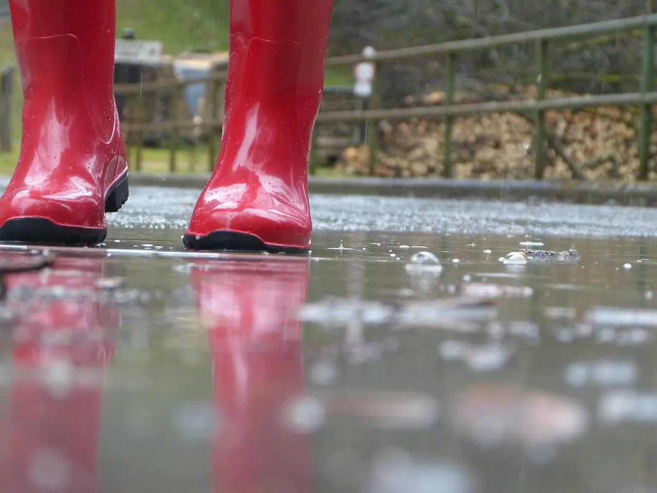 Rote Gummistiefel in einer Pfütze