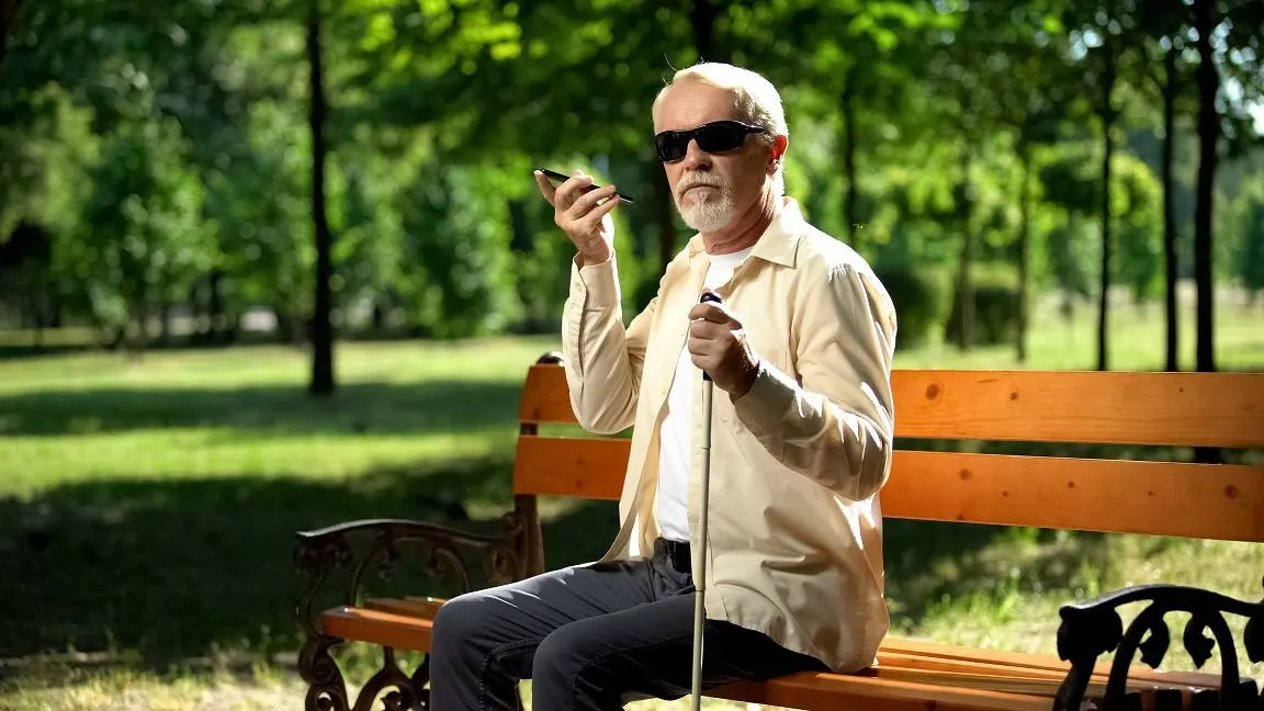 Blinder Mann hört Audio Nachricht mit dem Smartphone